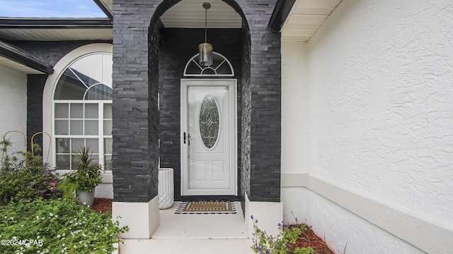 doorway to property featuring stucco siding