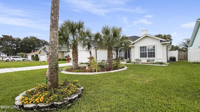 view of front of house featuring driveway, a front lawn, fence, and stucco siding