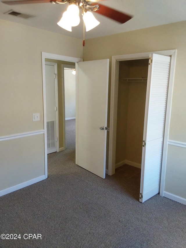 unfurnished bedroom featuring ceiling fan, a closet, and dark colored carpet