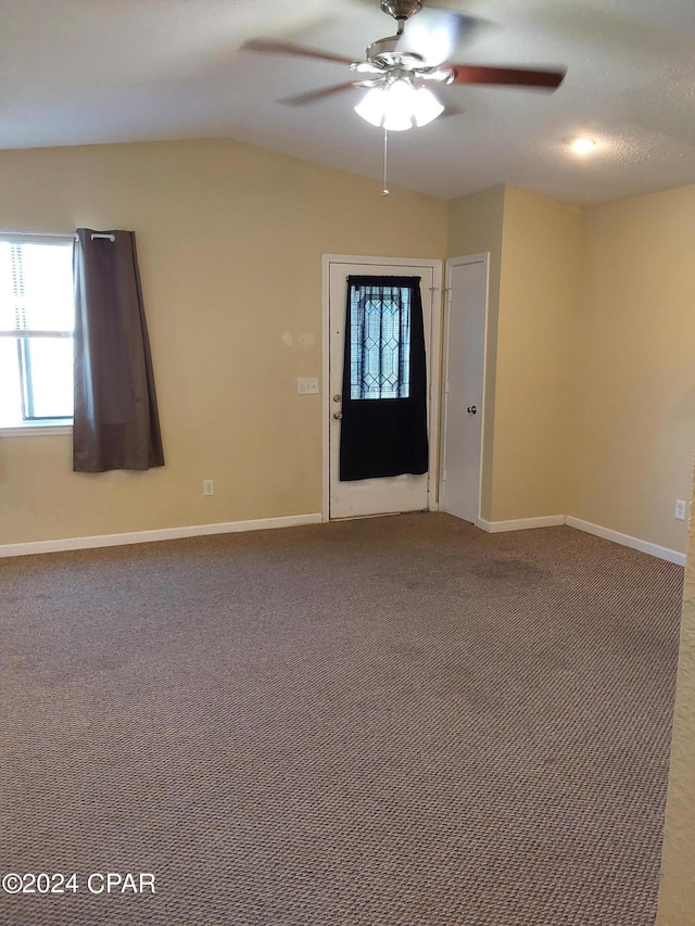 carpeted empty room featuring ceiling fan and vaulted ceiling