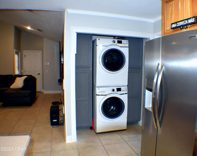 laundry room featuring stacked washer / dryer, light tile patterned flooring, and crown molding