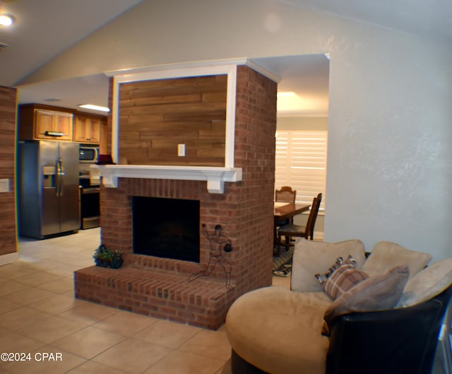 living room with vaulted ceiling, light tile patterned flooring, and a fireplace