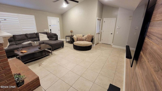 living room with ceiling fan, vaulted ceiling, and light tile patterned flooring