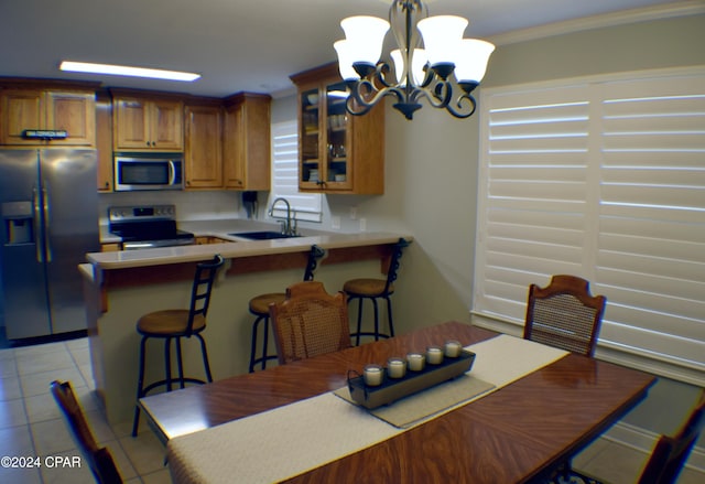 tiled dining room with sink, an inviting chandelier, and ornamental molding