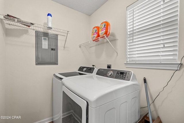 laundry area with electric panel, washer and dryer, and a textured ceiling