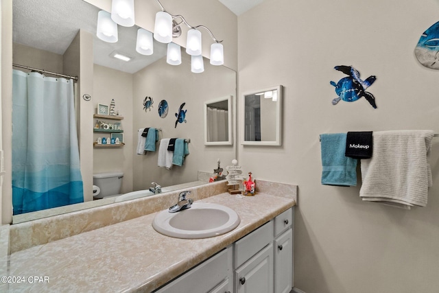 bathroom with vanity, a textured ceiling, and toilet