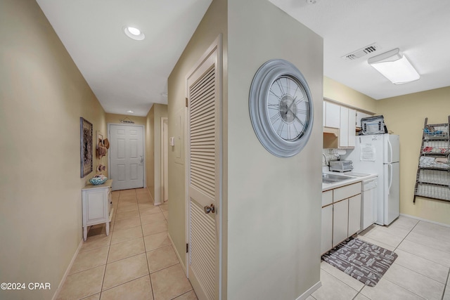 corridor with light tile patterned floors and sink