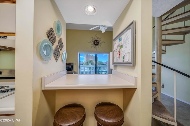 bar featuring white range oven, tile patterned flooring, extractor fan, and a textured ceiling