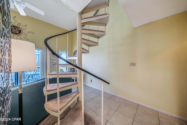 stairs featuring tile patterned flooring, vaulted ceiling, and ceiling fan