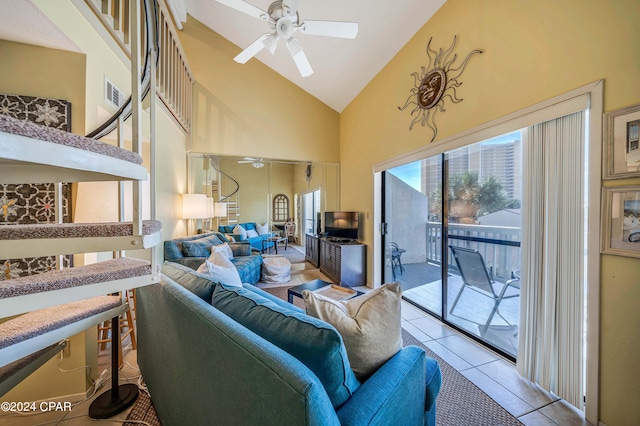 tiled living room featuring ceiling fan, high vaulted ceiling, and a skylight