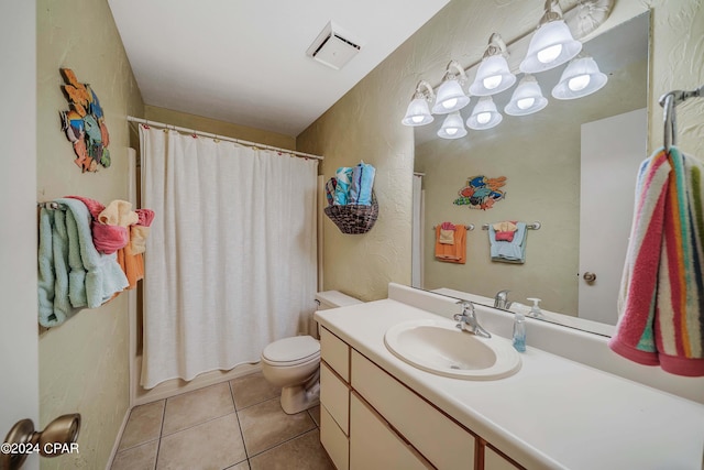 bathroom with toilet, vanity, and tile patterned floors