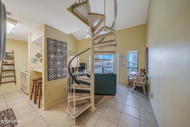 stairway featuring tile patterned floors and ceiling fan