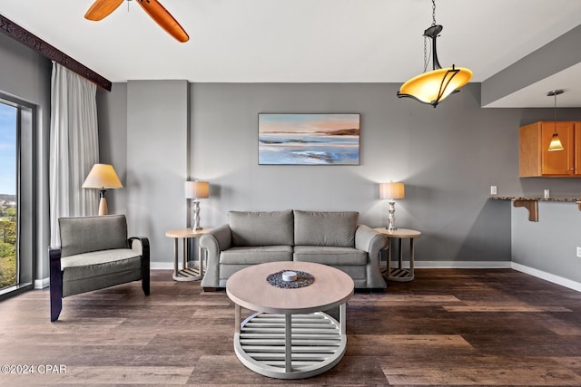 living room featuring a wealth of natural light, ceiling fan, and dark hardwood / wood-style flooring