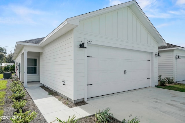 view of side of property featuring a garage and cooling unit