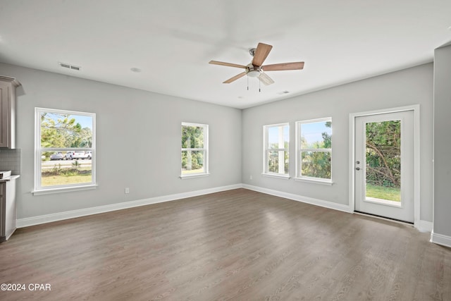 unfurnished living room with wood-type flooring and ceiling fan