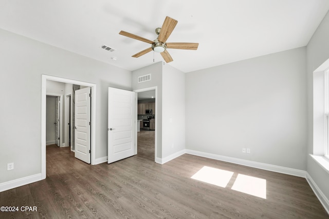 unfurnished bedroom with ceiling fan and dark hardwood / wood-style flooring