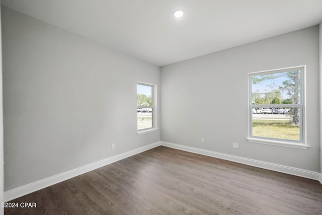 unfurnished room with a healthy amount of sunlight and dark hardwood / wood-style floors