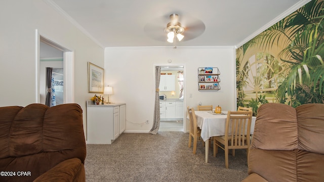 dining space with crown molding, ceiling fan, and light carpet