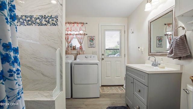 bathroom featuring washing machine and dryer, vanity, curtained shower, and hardwood / wood-style flooring