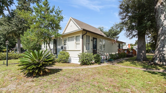 view of front of house with cooling unit and a front lawn