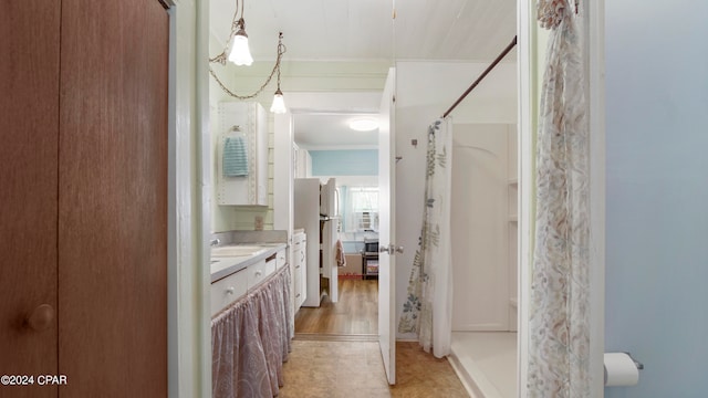 bathroom featuring hardwood / wood-style floors, walk in shower, and vanity