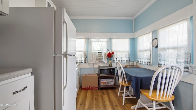 dining room with cooling unit, ornamental molding, and hardwood / wood-style floors