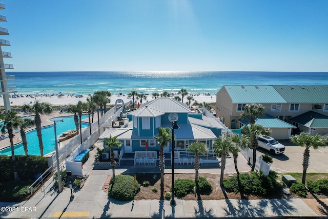 birds eye view of property with a water view and a beach view