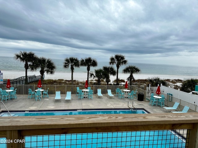 view of swimming pool with a patio and a water view