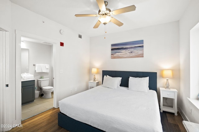 bedroom with dark hardwood / wood-style flooring, ceiling fan, and ensuite bath