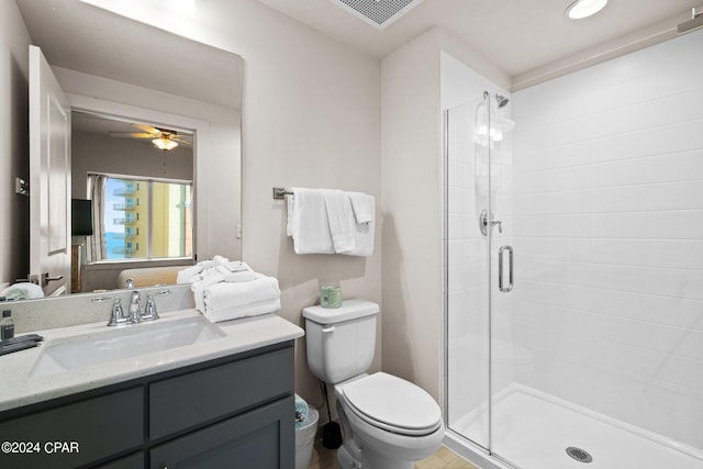 bathroom with walk in shower, vanity, toilet, and ceiling fan