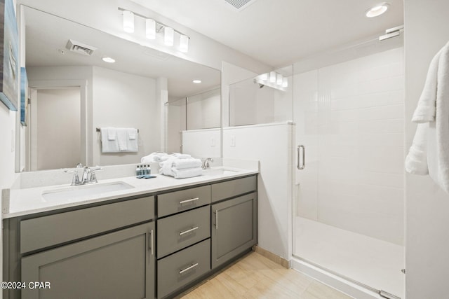 bathroom featuring walk in shower, vanity, and wood-type flooring