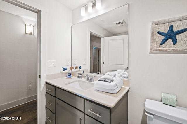 bathroom featuring vanity, toilet, and hardwood / wood-style flooring