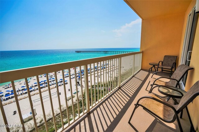 balcony featuring a water view and a beach view