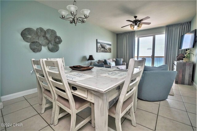 dining space with light tile patterned floors and ceiling fan with notable chandelier