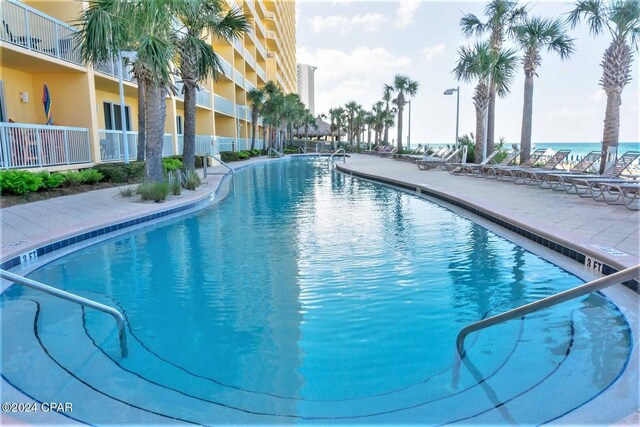 view of swimming pool featuring a patio and a water view