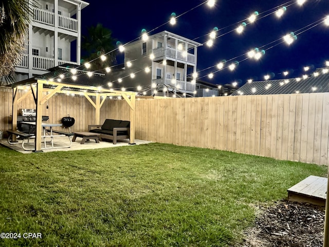 yard at night with a patio area and an outdoor hangout area