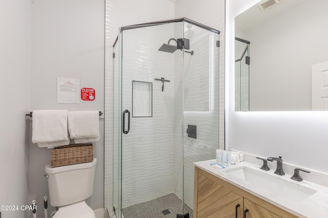 bathroom with vanity, an enclosed shower, and toilet