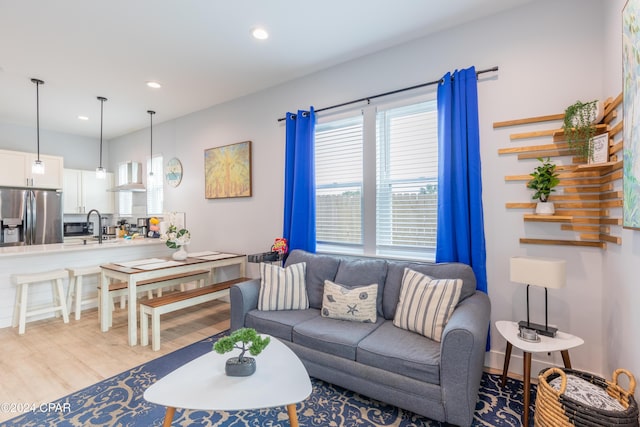 living room with sink and light hardwood / wood-style flooring