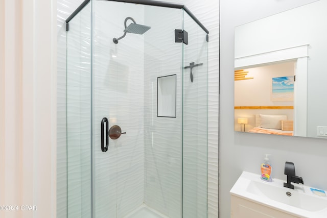 bathroom featuring a shower with door and sink