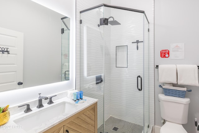 bathroom with vanity, a shower with shower door, and toilet