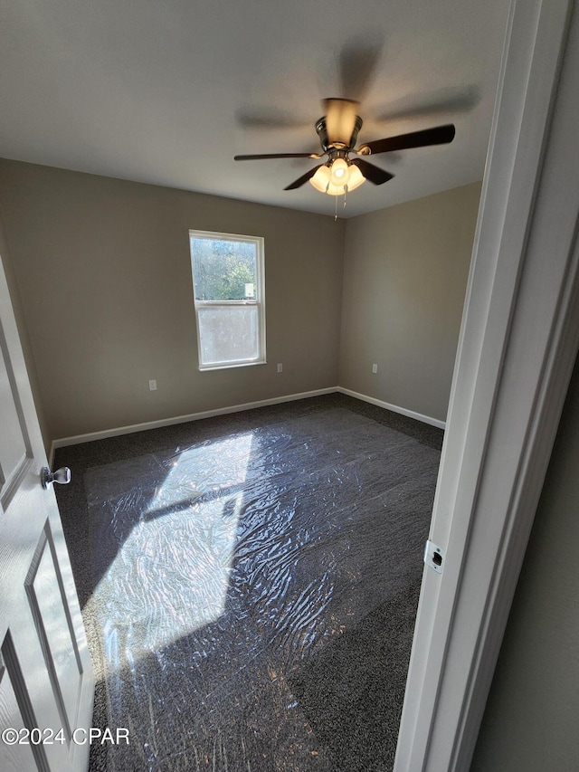 unfurnished room with ceiling fan and baseboards