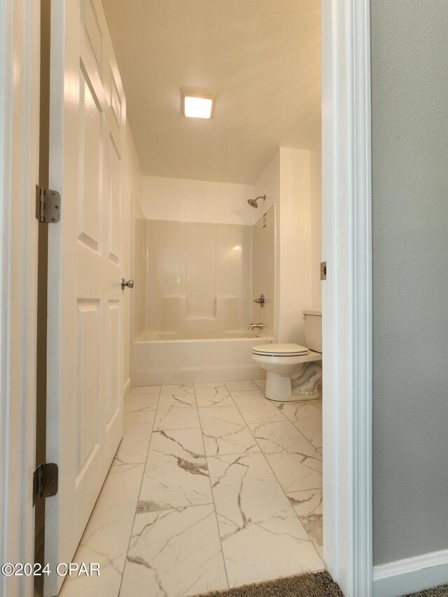 bathroom with marble finish floor, toilet, and baseboards