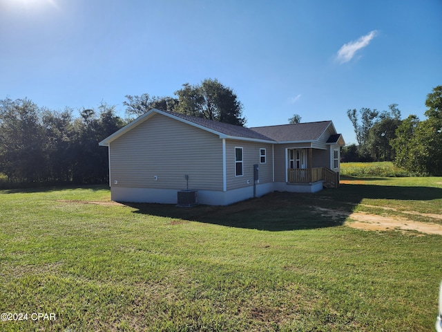 view of home's exterior with central AC and a yard