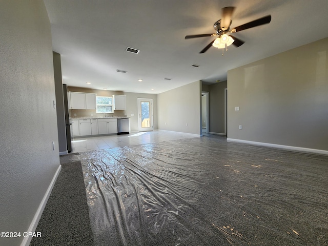 unfurnished living room featuring a ceiling fan, visible vents, a sink, and baseboards