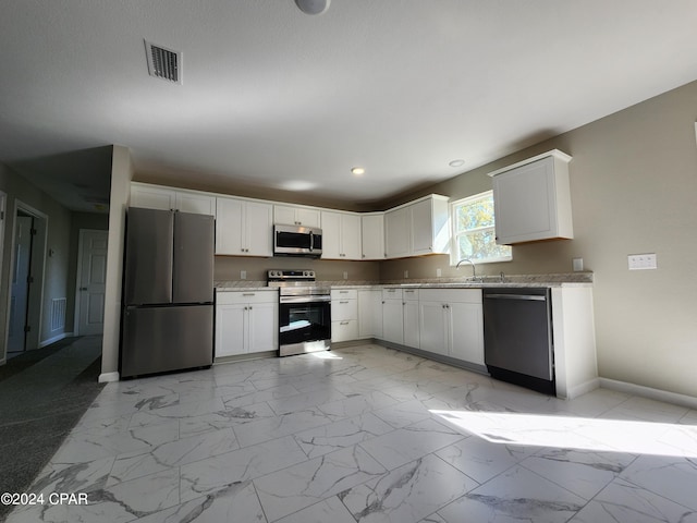 kitchen with stainless steel appliances, marble finish floor, visible vents, and a sink