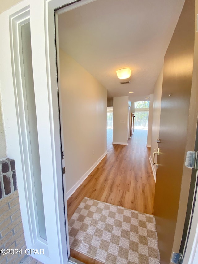 corridor with light hardwood / wood-style flooring