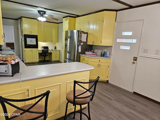 kitchen with kitchen peninsula, ceiling fan, light wood-type flooring, black oven, and stainless steel fridge with ice dispenser