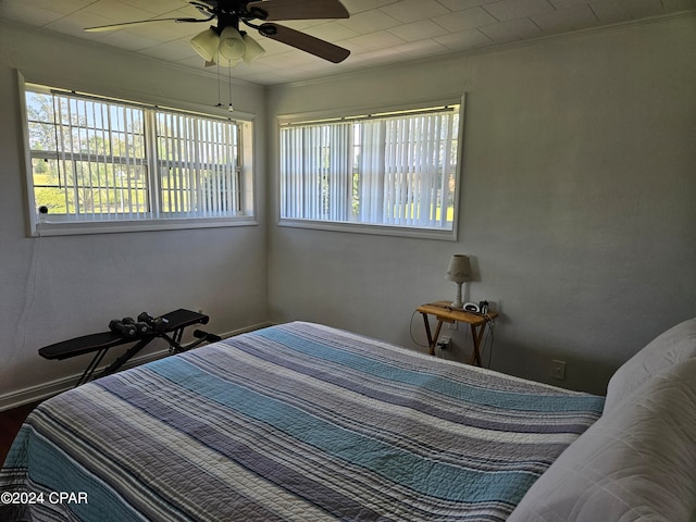 bedroom with ceiling fan and crown molding