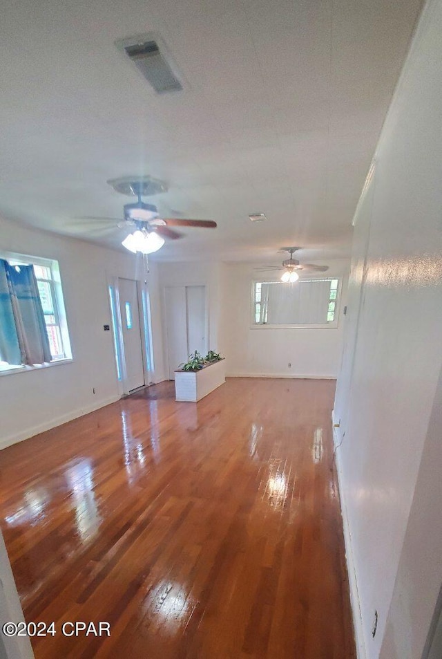 unfurnished living room featuring hardwood / wood-style floors and ceiling fan