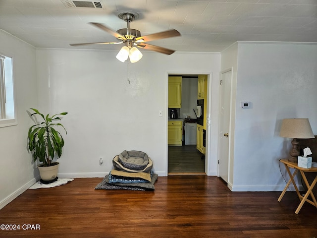 living area featuring ornamental molding, ceiling fan, and dark wood-type flooring